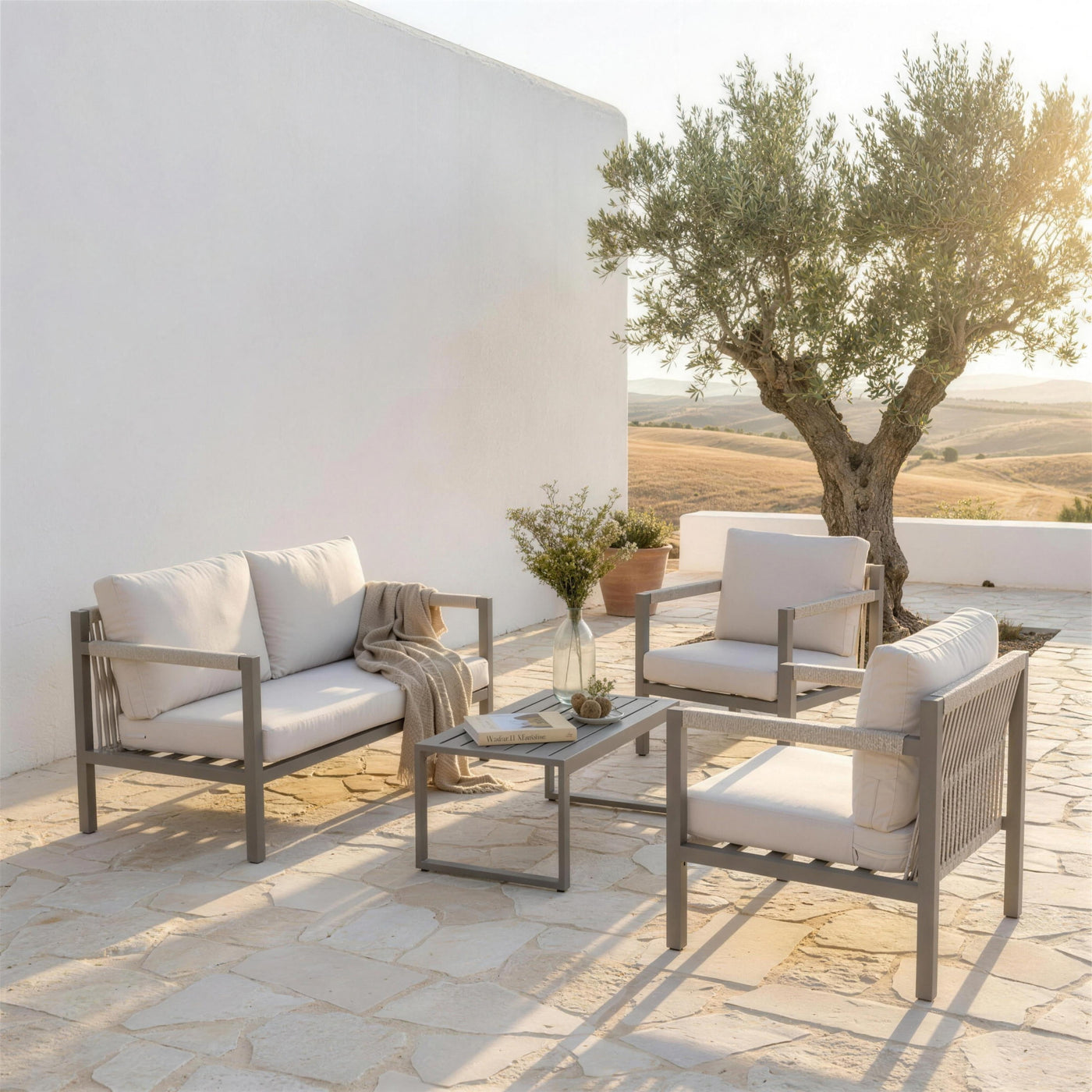 Set de jardin tortola en la terraza de un cortijo contemporaneo de la campina sevillana, junto a un olivo