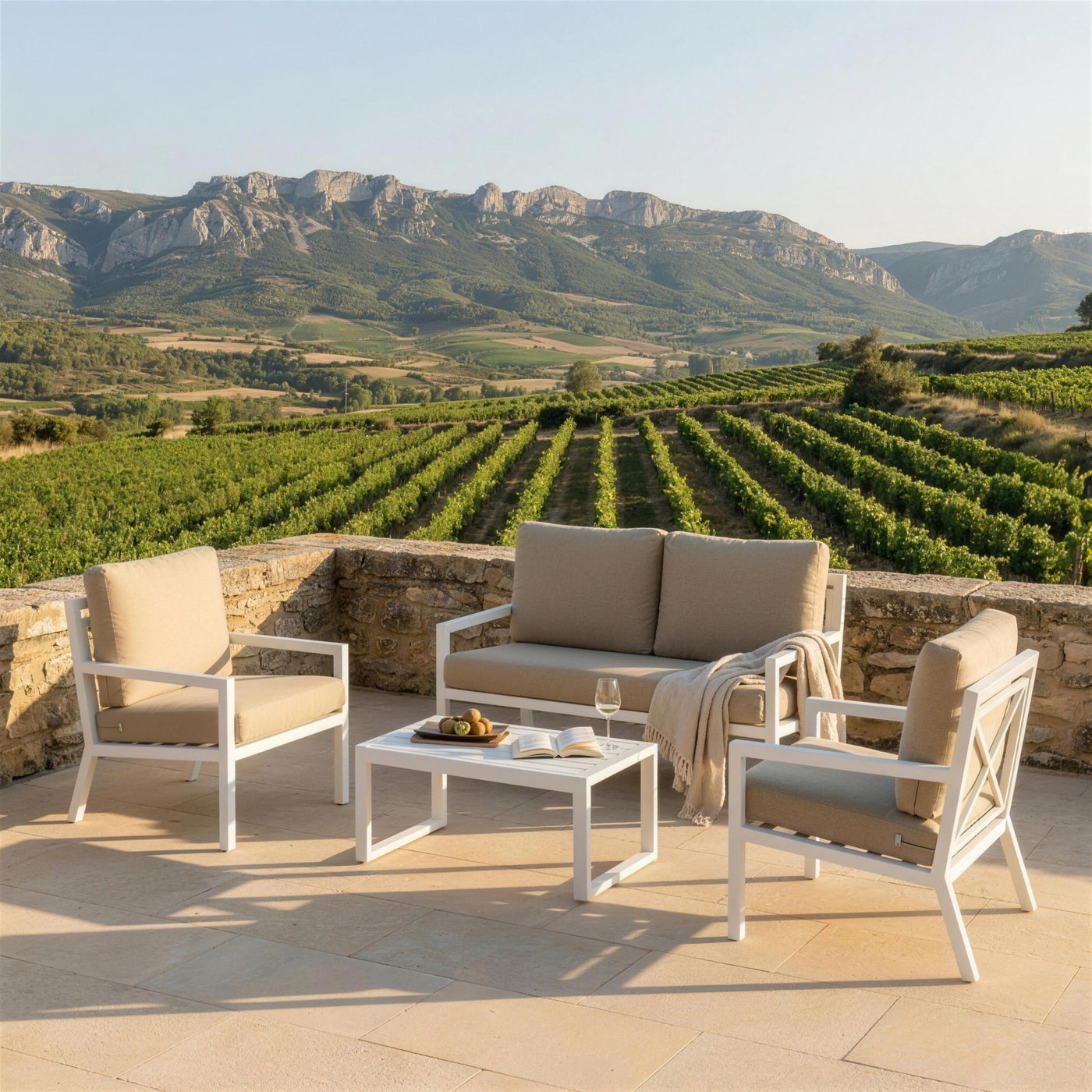 Conjunto Dounvil blanco en una terraza de piedra arenisca sobre los vinedos de La Rioja, con la Sierra de Cantabria al fondo