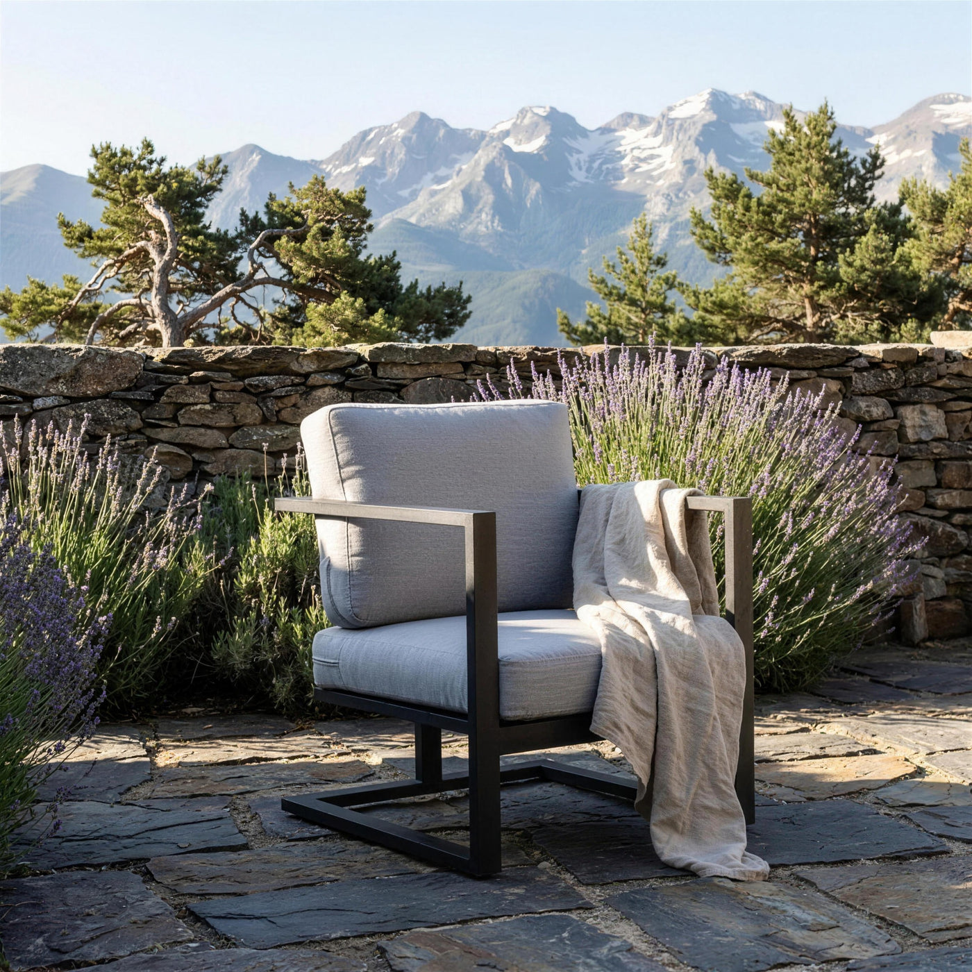 Sillon Manhatan antracita en una terraza de pizarra del Pirineo aragones, con muro de piedra seca, lavanda y los picos al fondo