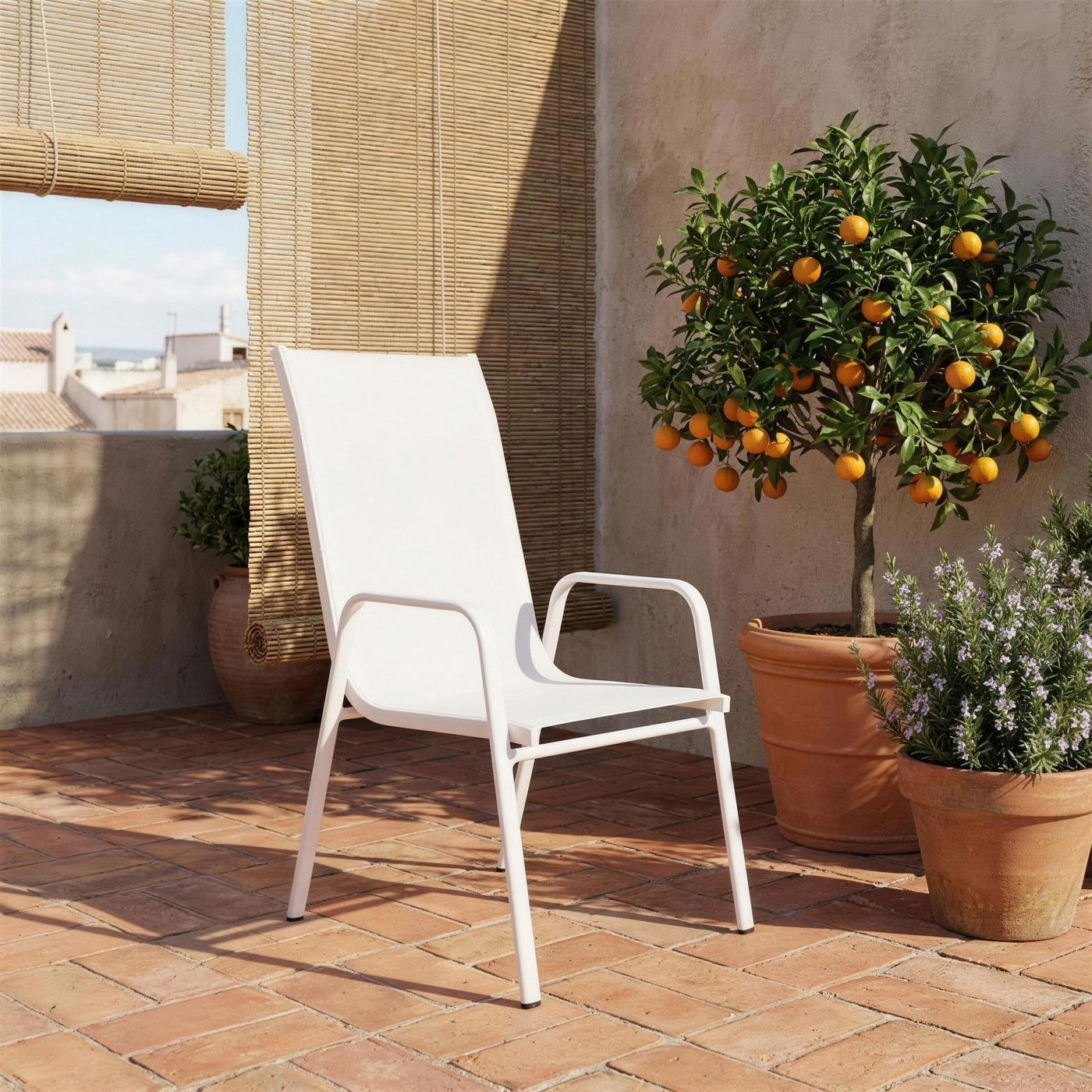 Silla Avalon blanca sola en una terraza valenciana de suelo de barro, con persiana de esparto, romero y un naranjo en tinaja