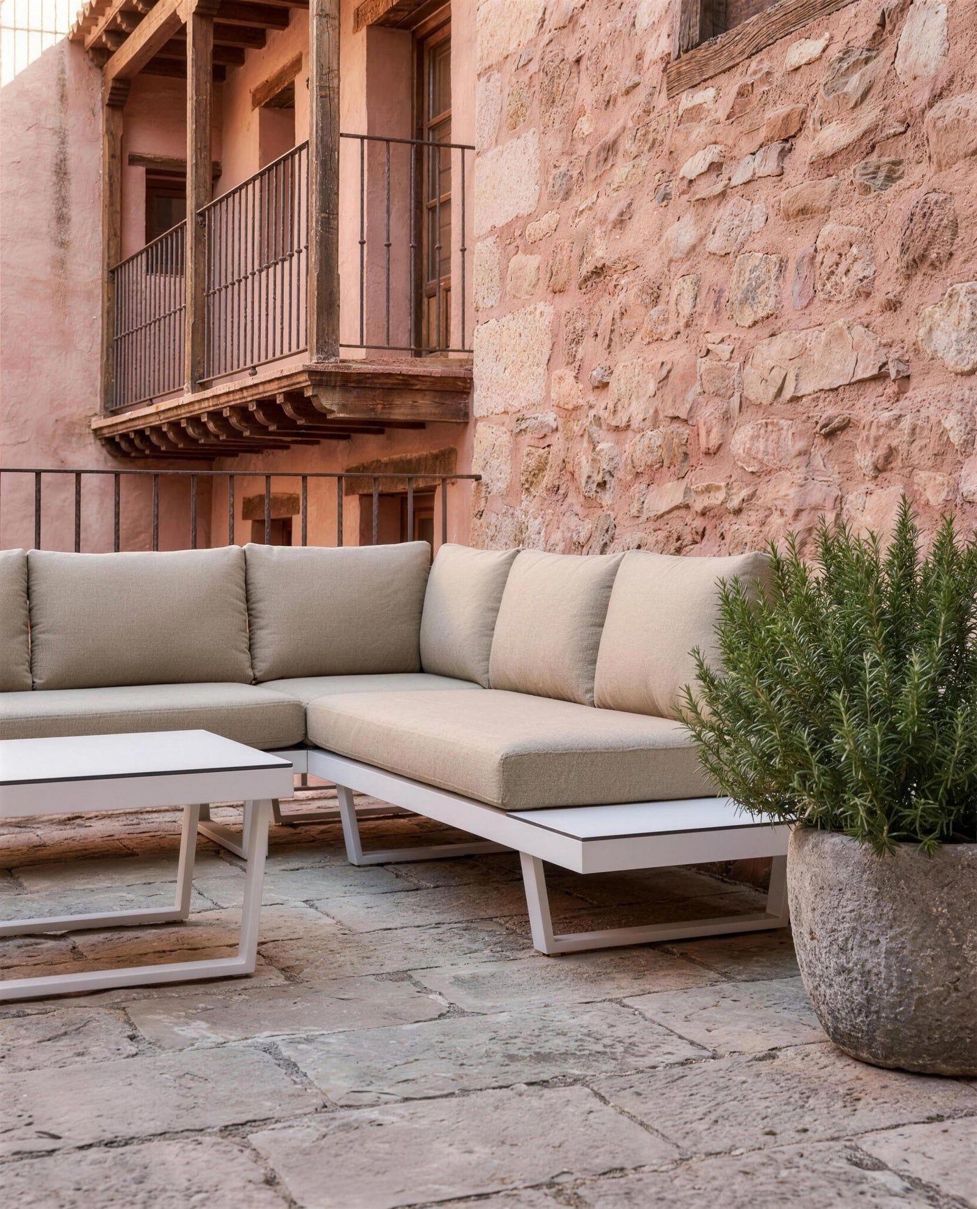 Detalle de la rinconera Loira-7 junto al muro de piedra rosada y el balcon de madera de Albarracin, con romero en una maceta de piedra