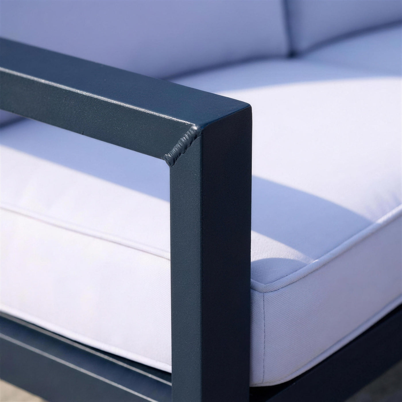 Detalle de la esquina soldada del brazo de aluminio azul marino del sofa Bolonia XL, junto al canto del cojin azul lavanda