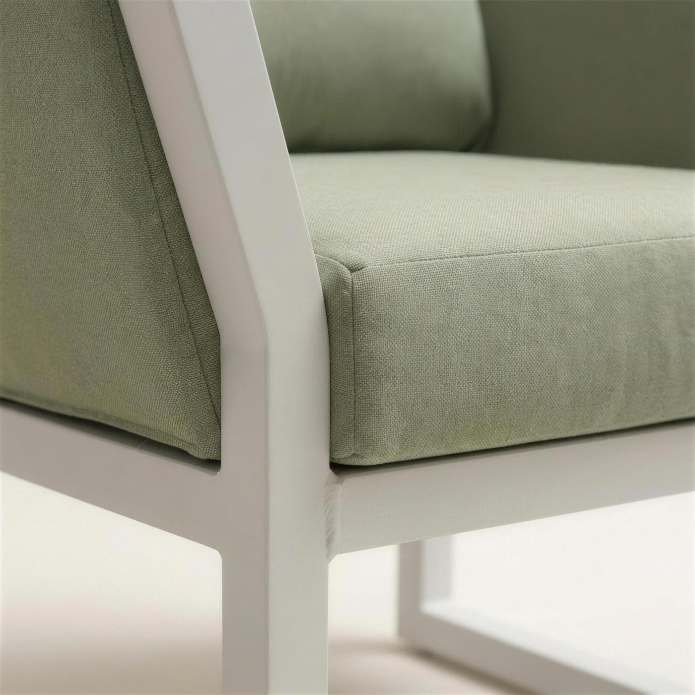 Detalle del brazo de aluminio blanco lacado del sofa Cupra y la trama del cojin verde salvia