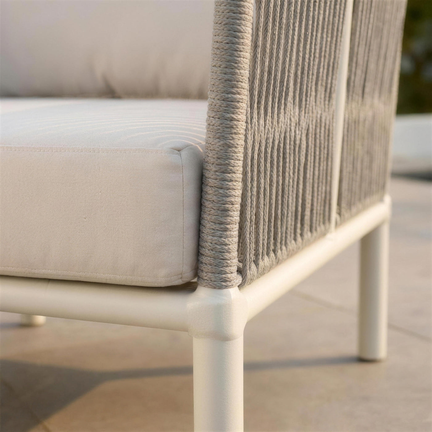 Detalle del encuentro entre el tubo blanco del sillon Cloe, el panel de cuerda gris y el canto del cojin crudo