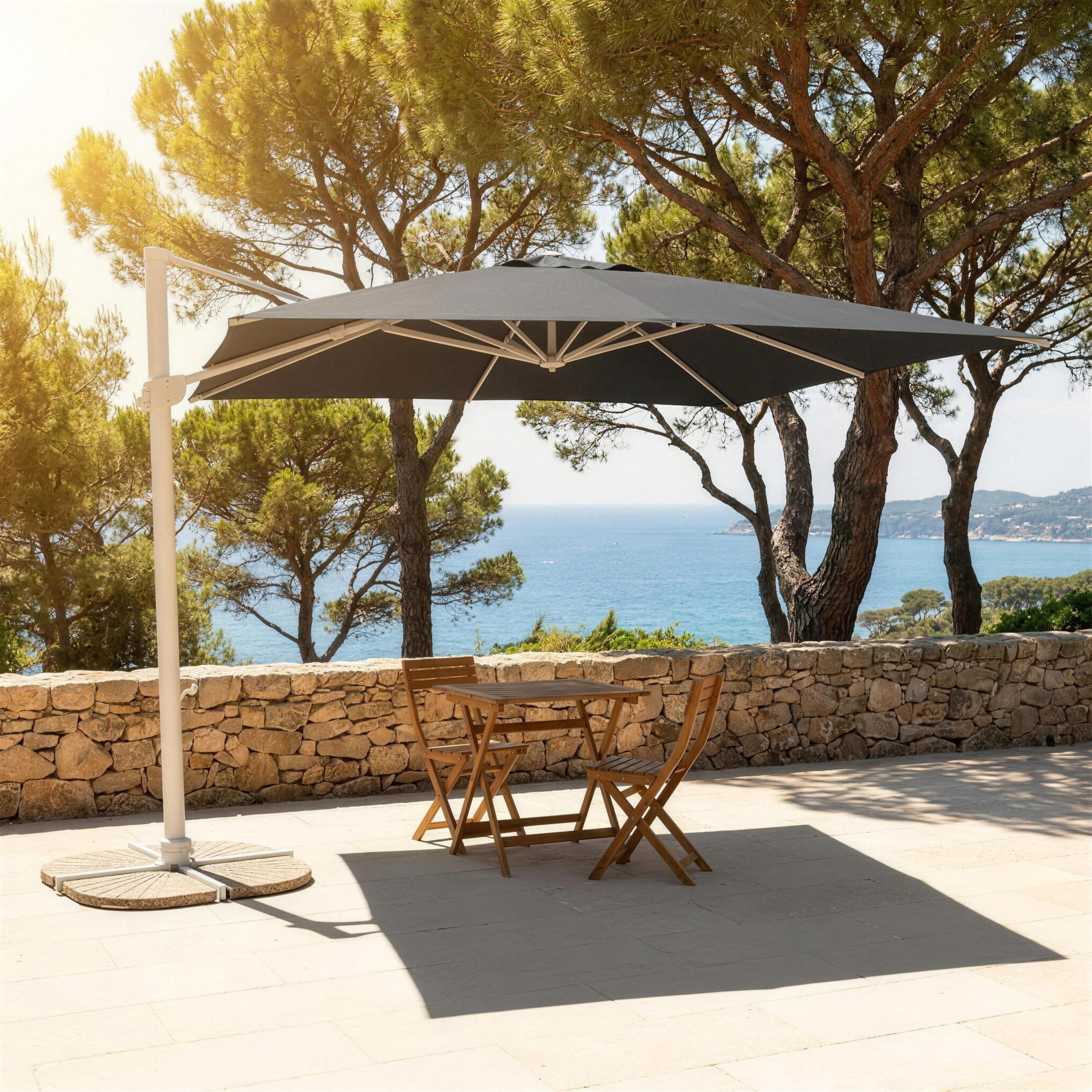 Parasol excéntrico con base de losas de cemento en una terraza junto al mar