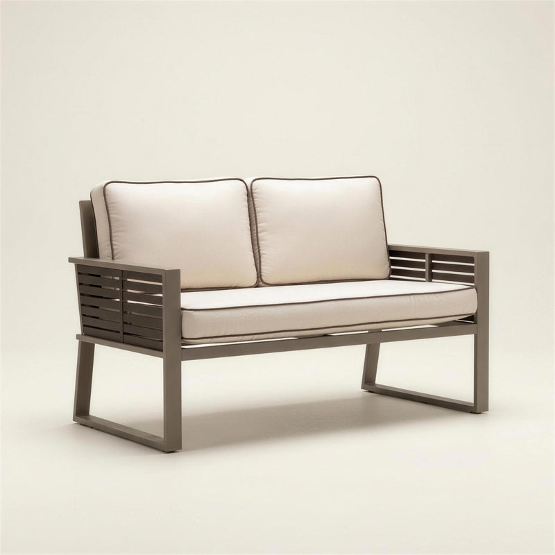 Sofa de terraza Diva bicolor de 2 plazas con estructura de aluminio tortola, laterales de lamas marron oscuro y cojines crudo con ribete, 140x70x76 cm, sobre fondo neutro