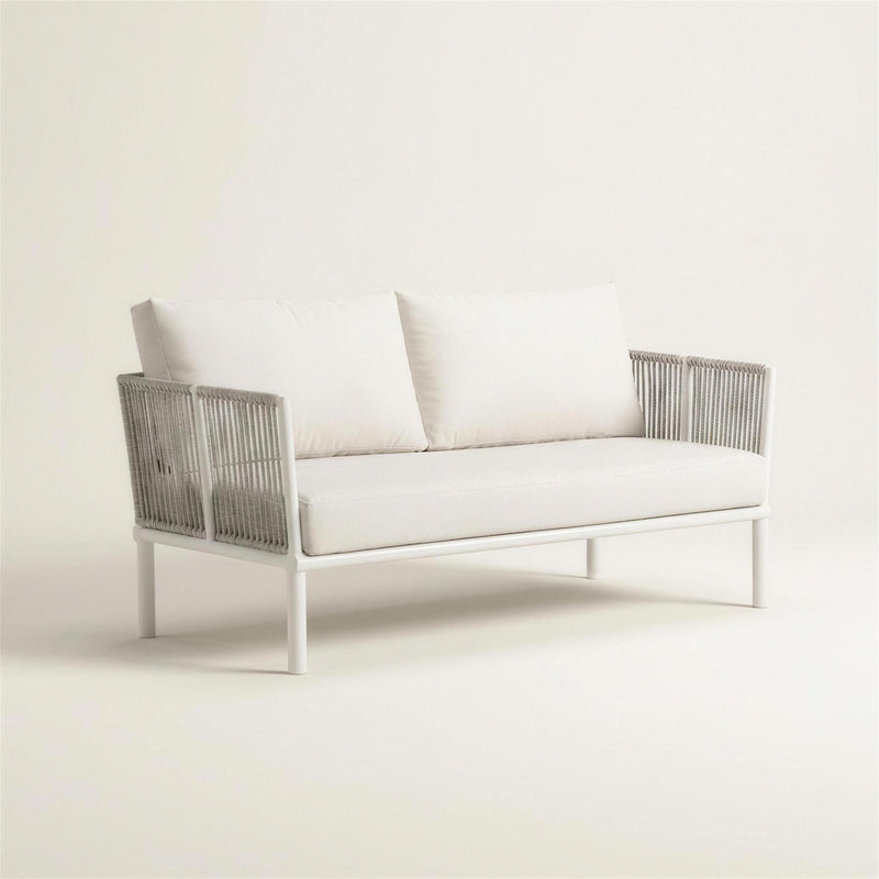 Sofa de terraza Cloe de 2 plazas con estructura de tubo redondo blanco, laterales de cuerda gris trenzada y cojines blanco crudo, 162x64x69 cm, sobre fondo neutro