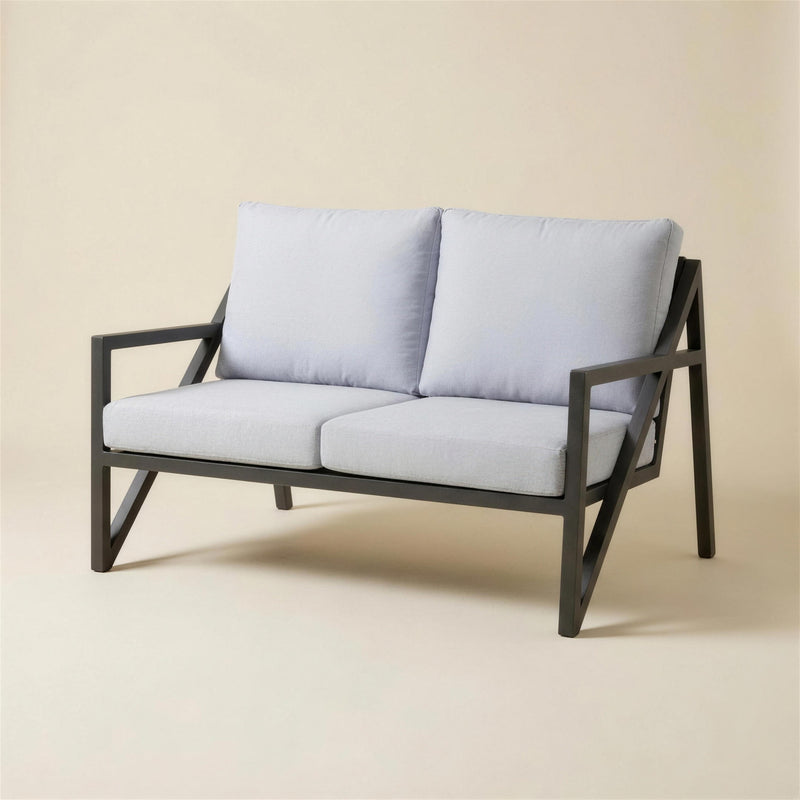 Sofa de terraza Albania de 2 plazas con estructura de aluminio antracita, travesano diagonal en V en el lateral y cojines gris claro, 145x70x100 cm, sobre fondo neutro