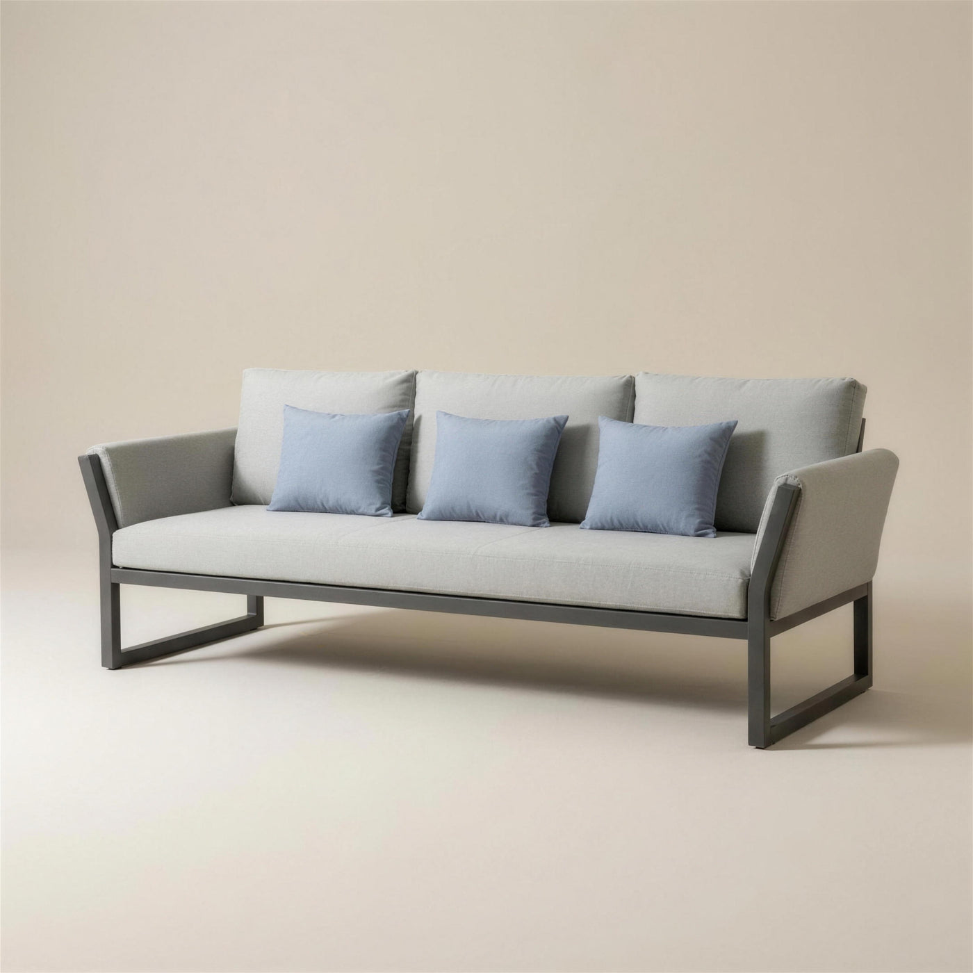Sofa de terraza Cupra de 3 plazas con estructura de aluminio antracita, brazos tapizados, cojines gris claro y tres cojines de acento azules, 185x75x90 cm, sobre fondo neutro