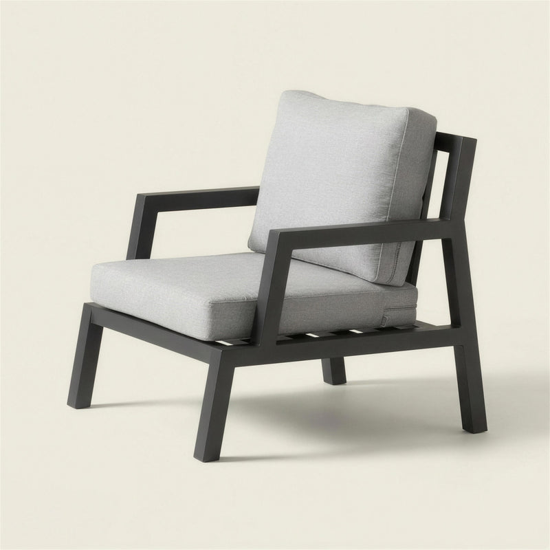 Sillon de exterior Leisa con estructura de aluminio antracita y cojines gris claro, 76x80x85 cm, sobre fondo neutro