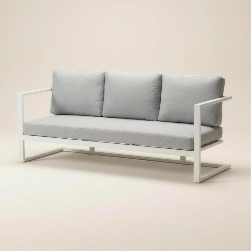 Sofa de terraza Manhatan de 3 plazas en aluminio blanco con brazos planos y base voladiza, cojines gris claro, 187x66x70 cm, sobre fondo neutro