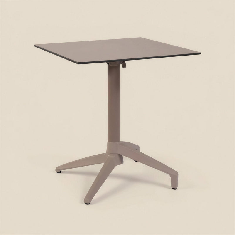 Mesa de exterior Altea de 70x70 cm con tablero topo de canto negro, columna central y base de estrella en color tortola, sobre fondo neutro