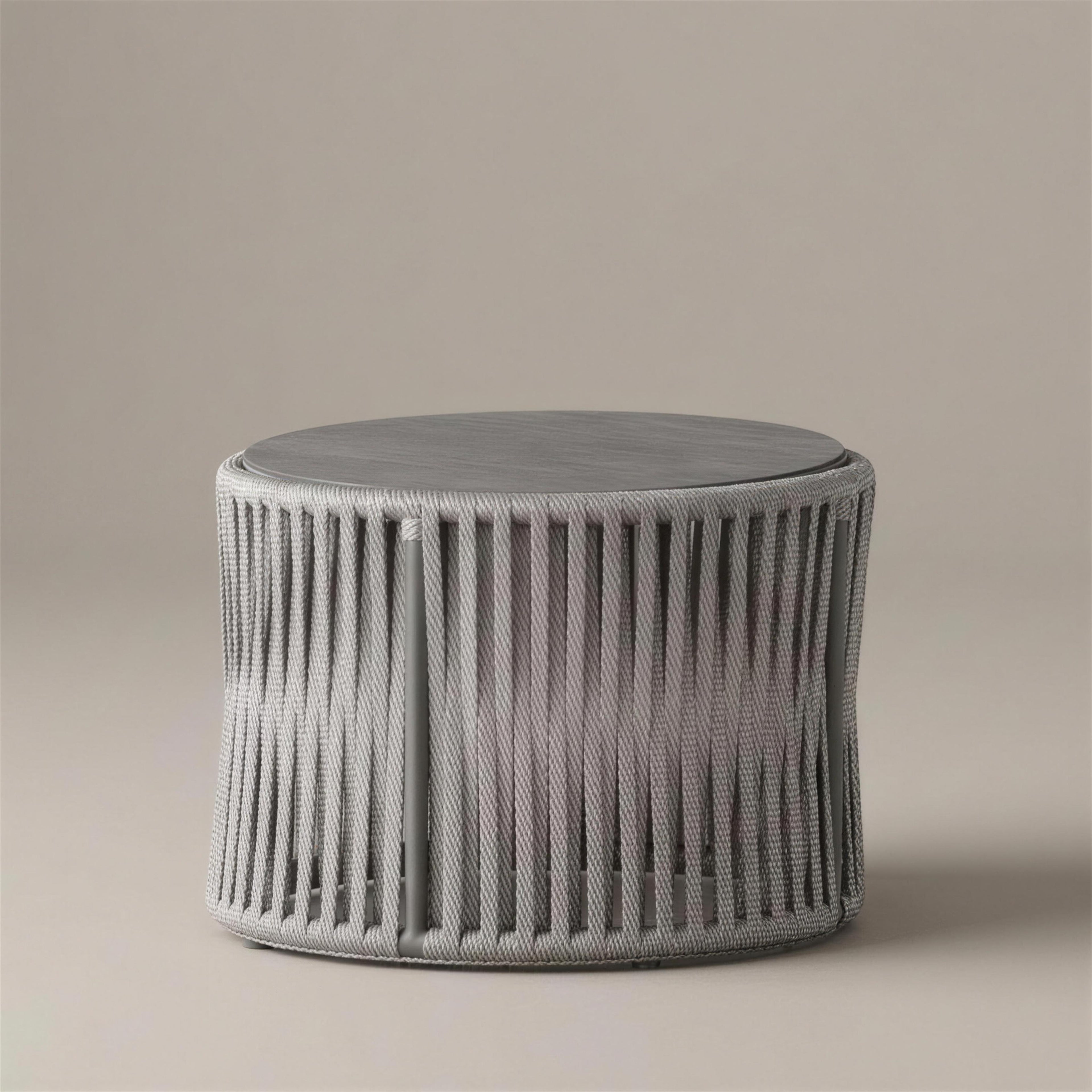 Mesa de centro Yina redonda de 70 cm con faldon de cuerda trenzada gris y tablero HPL gris oscuro, sobre fondo neutro