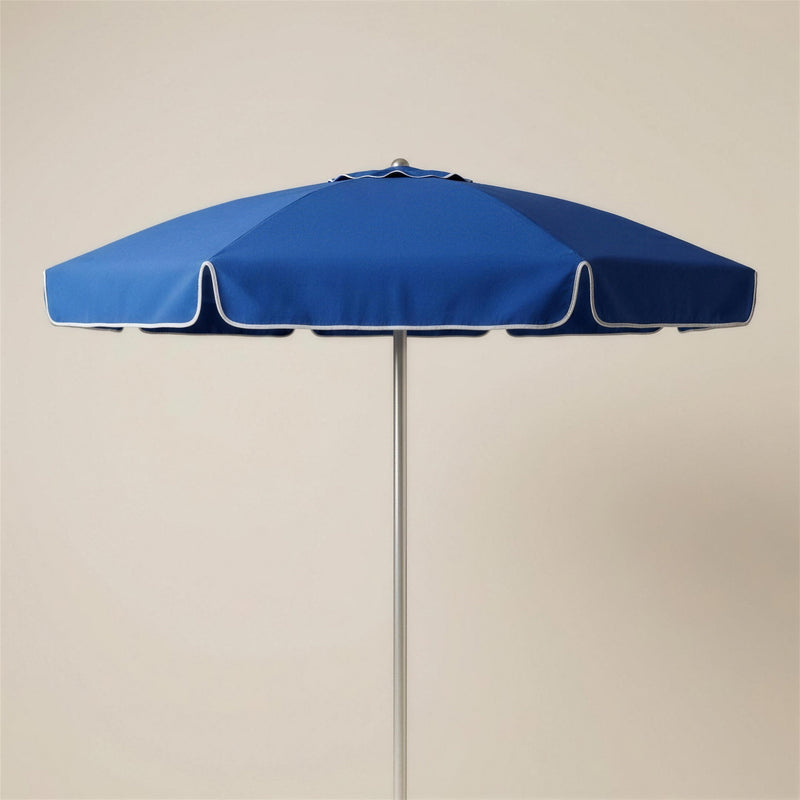 Parasol redondo de exterior Ocean en tejido acrilico azul, con mastil de aluminio, sobre fondo neutro. El pie se vende por separado