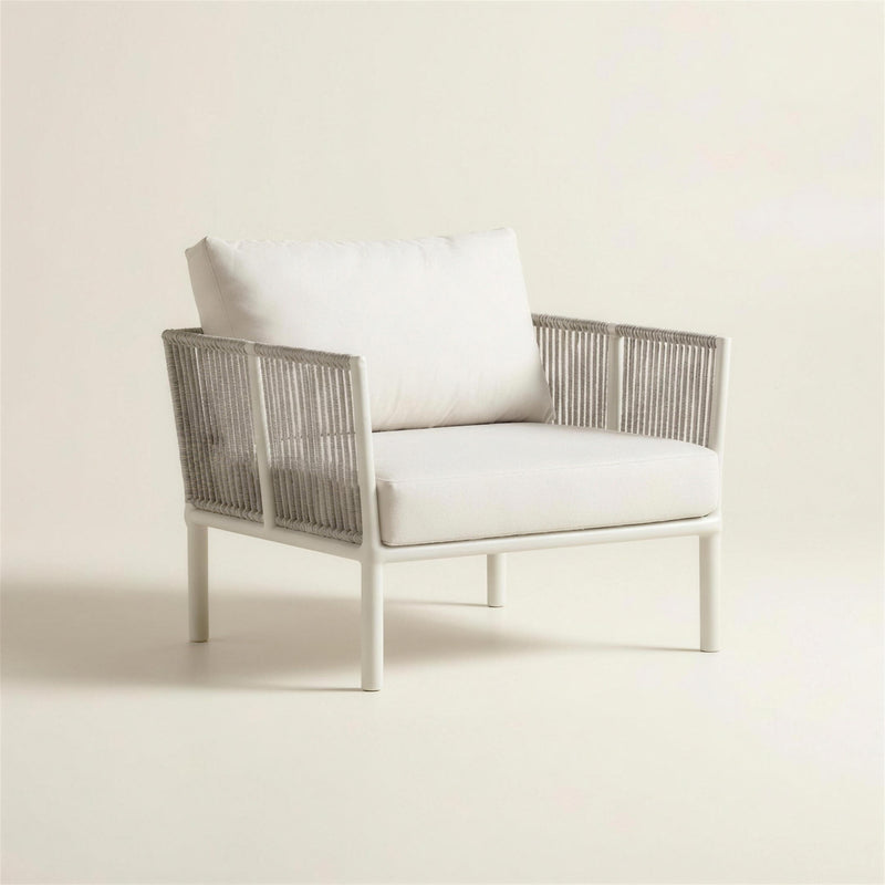 Sillon de exterior Cloe con estructura de tubo redondo blanco, laterales de cuerda gris trenzada y cojines blanco crudo, 70x64x69 cm, sobre fondo neutro