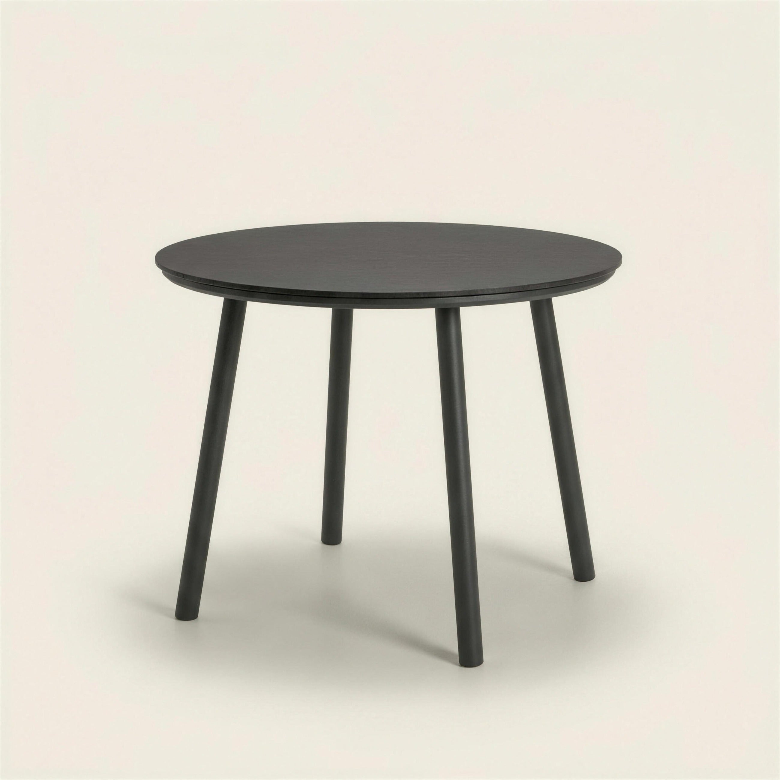 Mesa de comedor de exterior Mundra, redonda de 100 cm con tablero HPL y cuatro patas cilindricas de aluminio antracita, 76 cm de alto, sobre fondo neutro