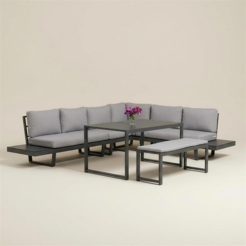 Set rinconera de exterior Loira-30 con estructura de aluminio antracita, siete cojines gris claro, mesa alta de tablero HPL y banco a juego, sobre fondo neutro