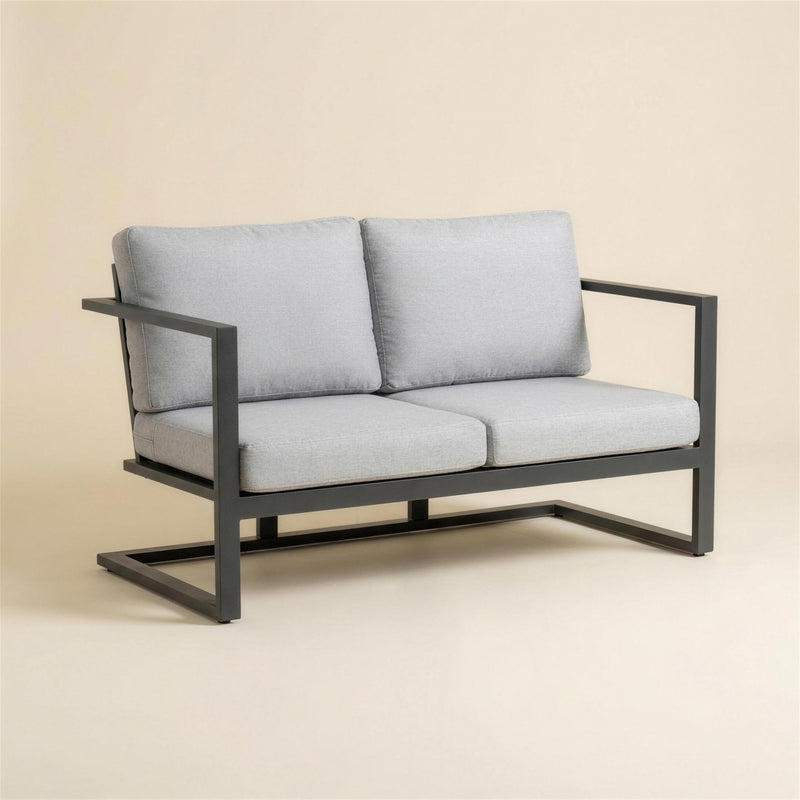 Sofa de terraza Manhatan de 2 plazas con estructura de aluminio antracita de brazo plano y base de patin, con cojines gris claro, 133x66x70 cm, sobre fondo neutro