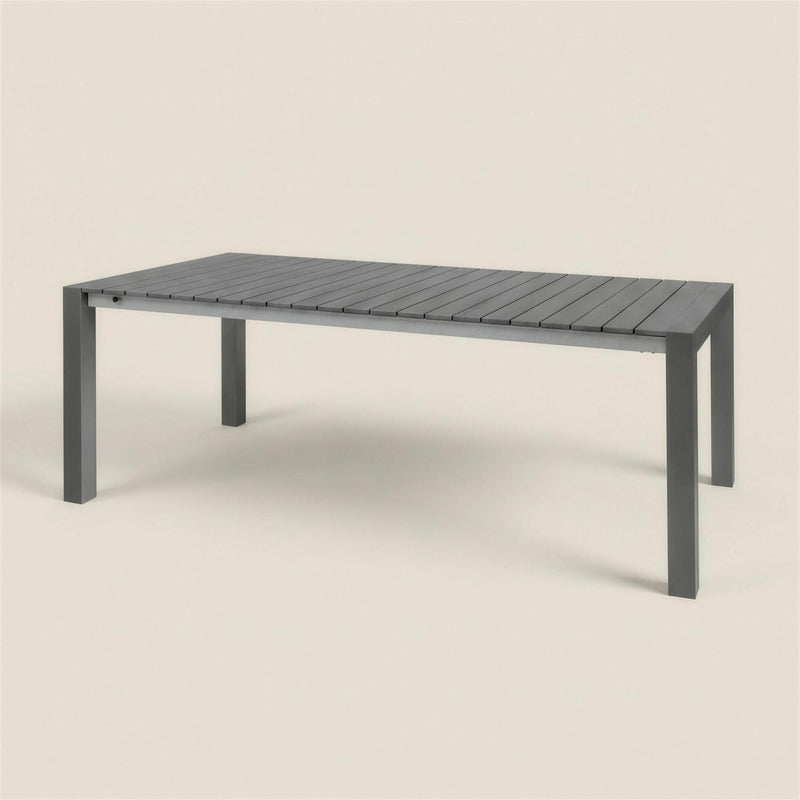 Mesa extensible de exterior Atlanta en aluminio antracita con tablero de listones estrechos, sobre fondo neutro. Se vende solo la mesa, sin sillas