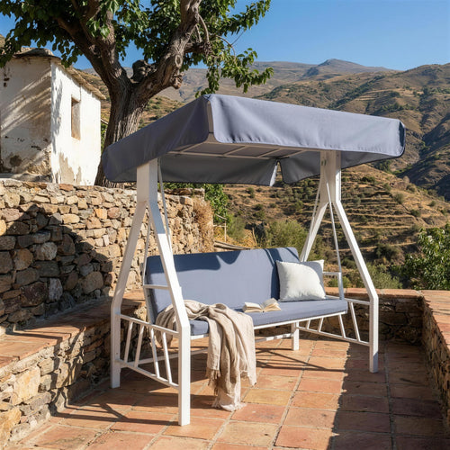 Balancin blanco en una terraza de piedra de la Alpujarra granadina, con muro de mamposteria, suelo de barro y las terrazas de la sierra al fondo