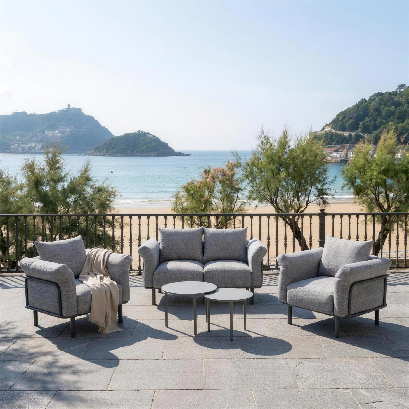 Conjunto de jardin antracita en una terraza de piedra sobre la bahia de La Concha en San Sebastian, con la isla de Santa Clara y el monte Urgull al fondo