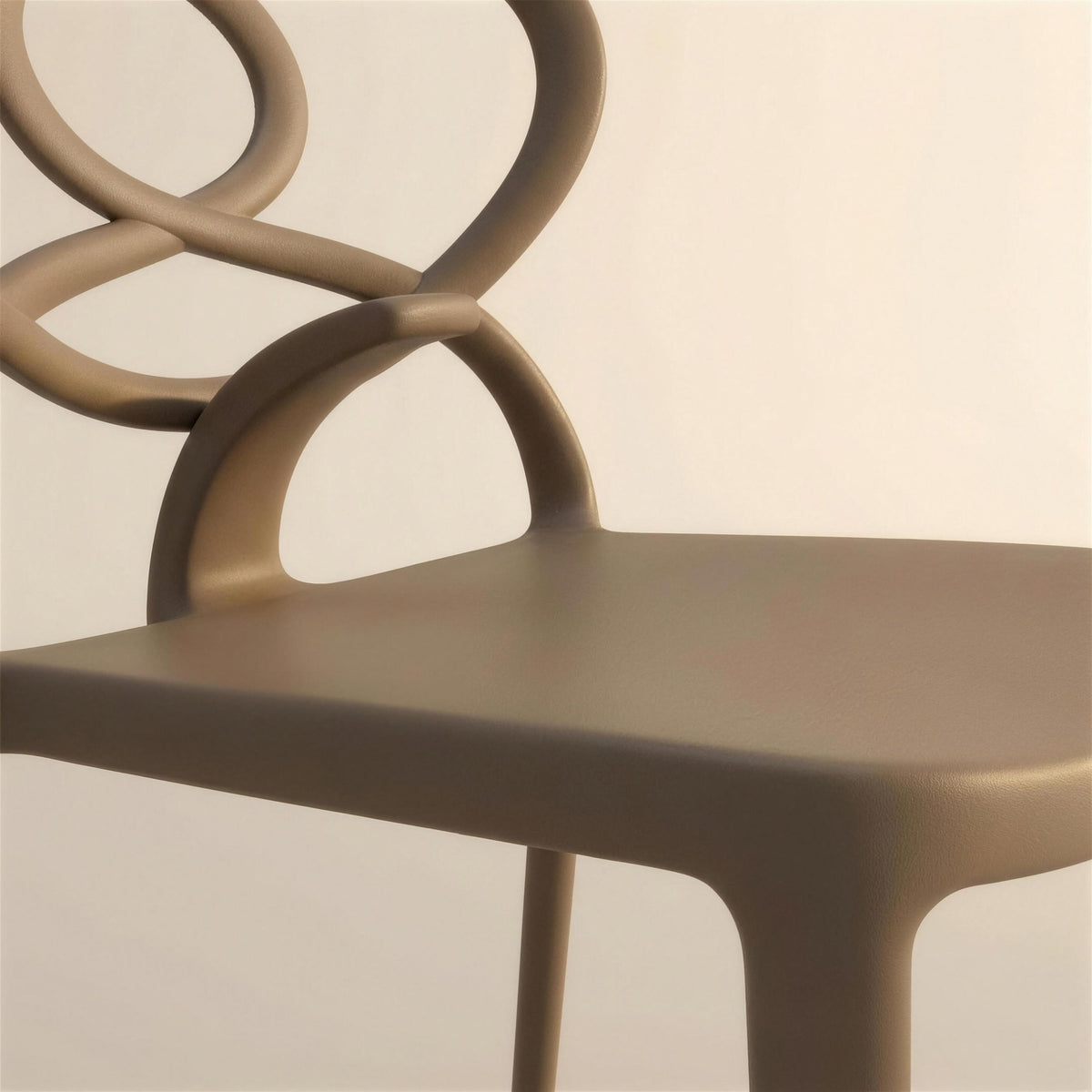 Detalle del asiento de resina color tortola y de su union con el respaldo de lazos de la silla Venus