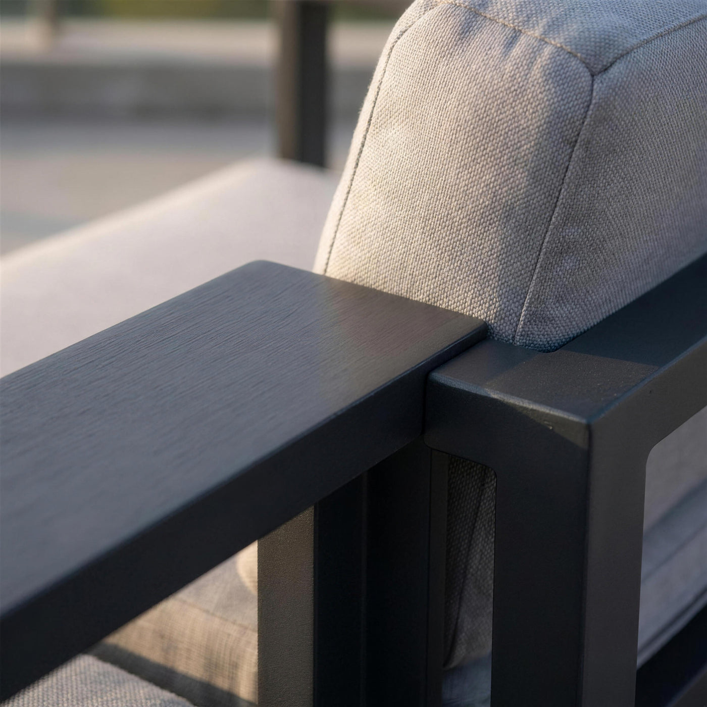 Detalle del brazo de aluminio antracita del sillon Odin y su union con el cojin gris claro