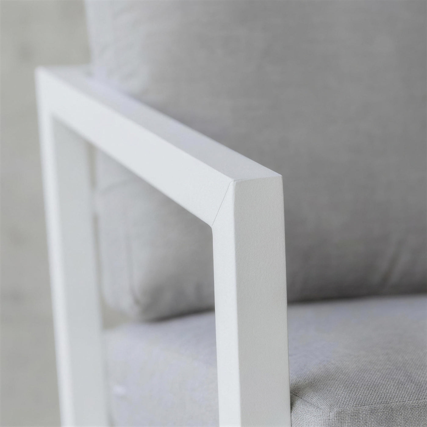 Detalle del brazo de marco abierto de aluminio blanco del sofa Acapulco, en la union del travesano con el montante