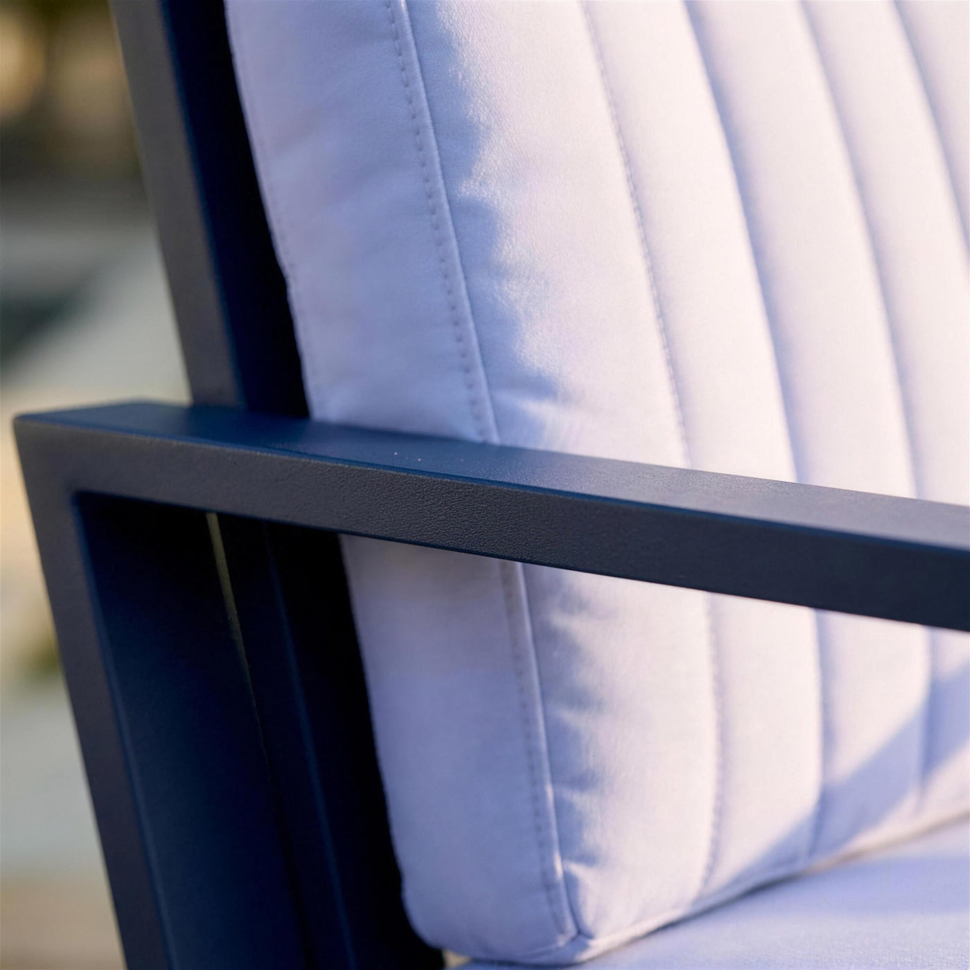 Detalle del brazo de aluminio azul marino del sillon Bolonia XL y del acolchado acanalado del cojin de respaldo