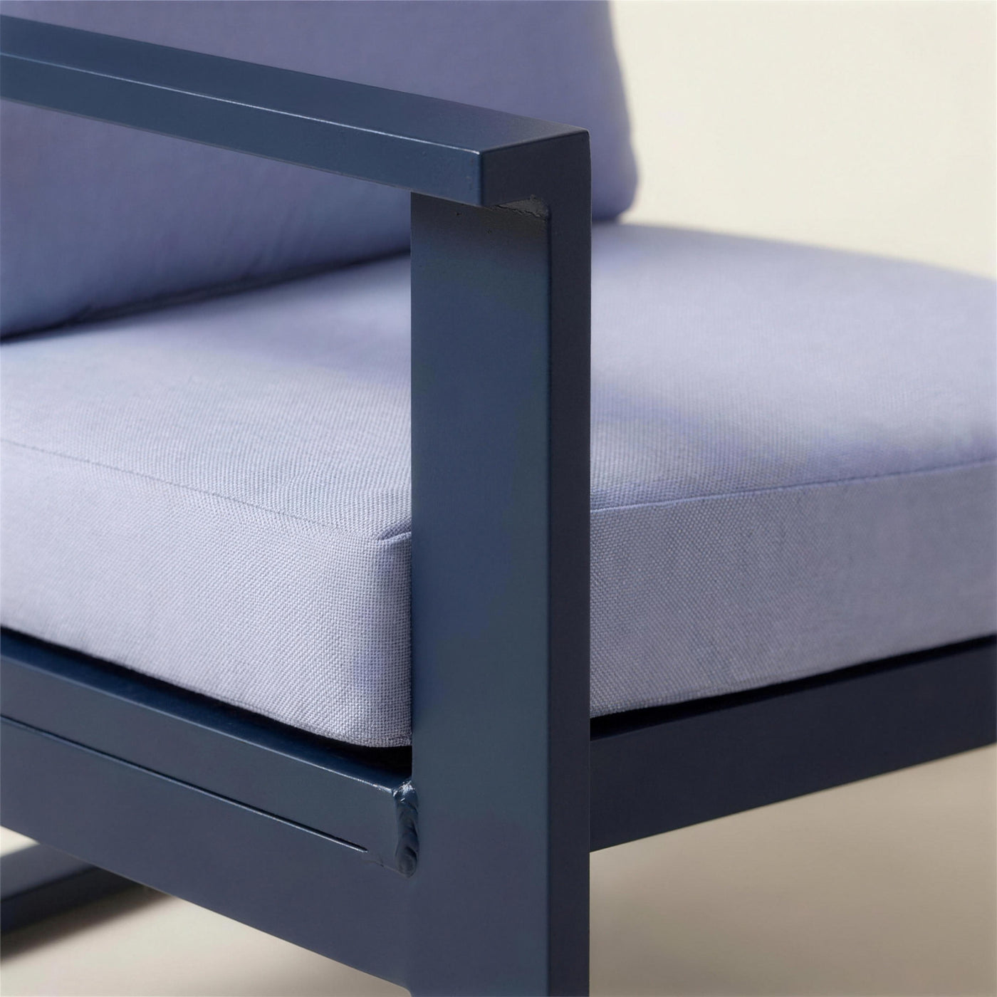 Detalle del brazo de aluminio azul marino del sofa Bolonia XL junto a la trama del cojin azul lavanda