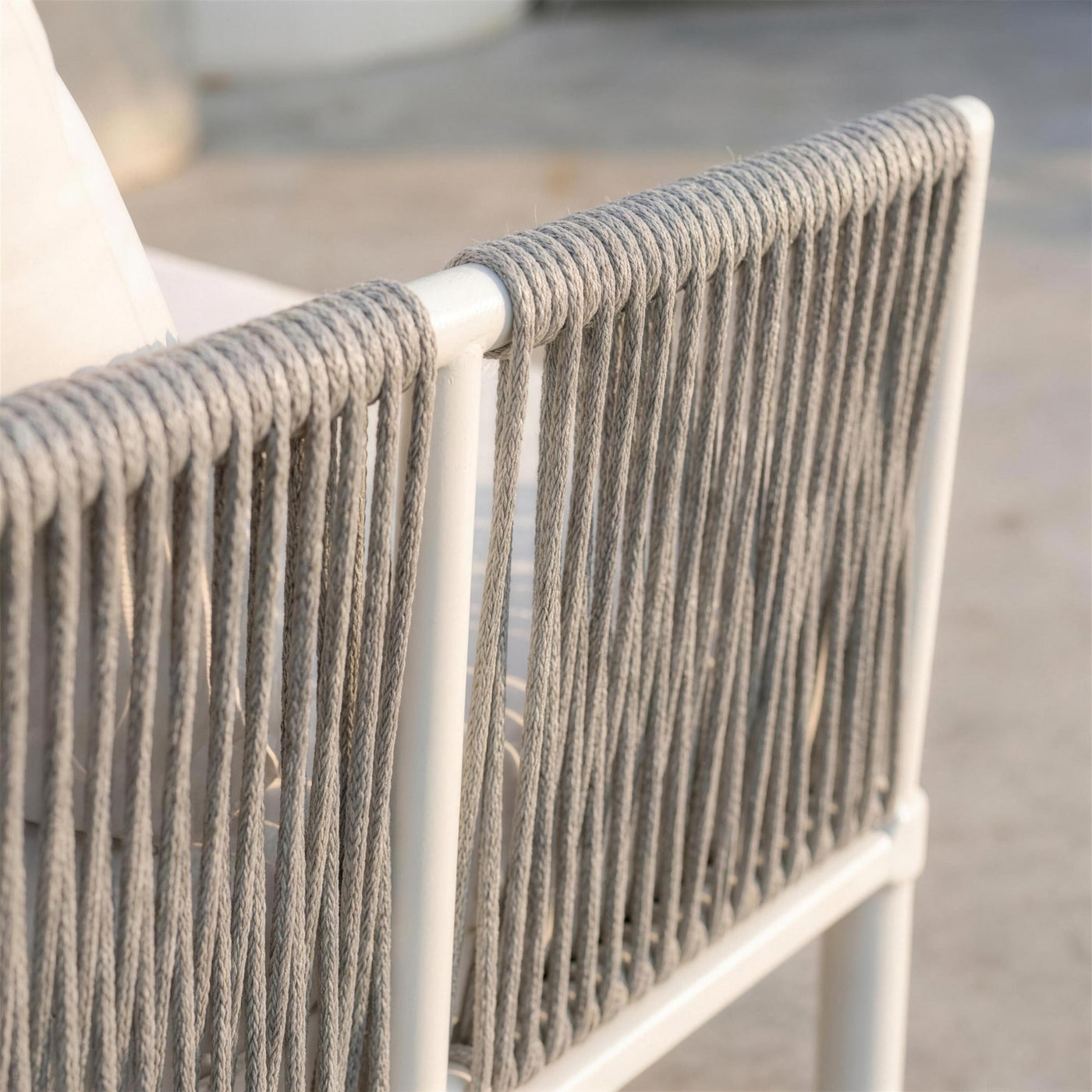 Detalle de la cuerda gris enrollada en vertical sobre el tubo blanco del lateral del sofa Cloe