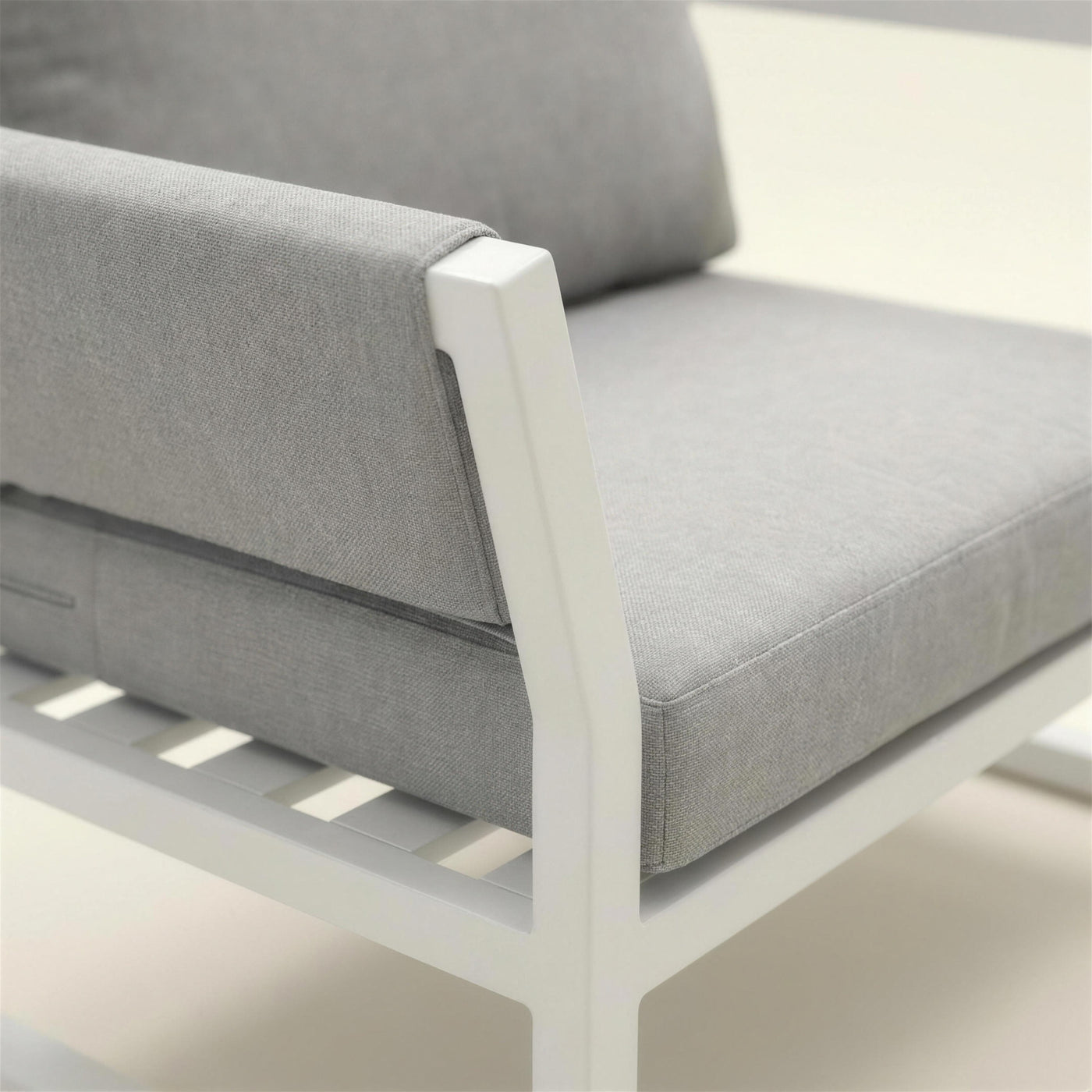 Detalle del perfil de aluminio blanco del sillon Cupra, con las lamas del asiento y la trama del cojin gris claro