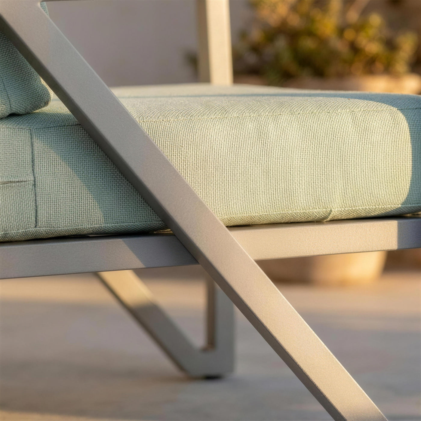 Detalle del perfil de aluminio gris claro del sillon Albania y del canto del cojin verde salvia