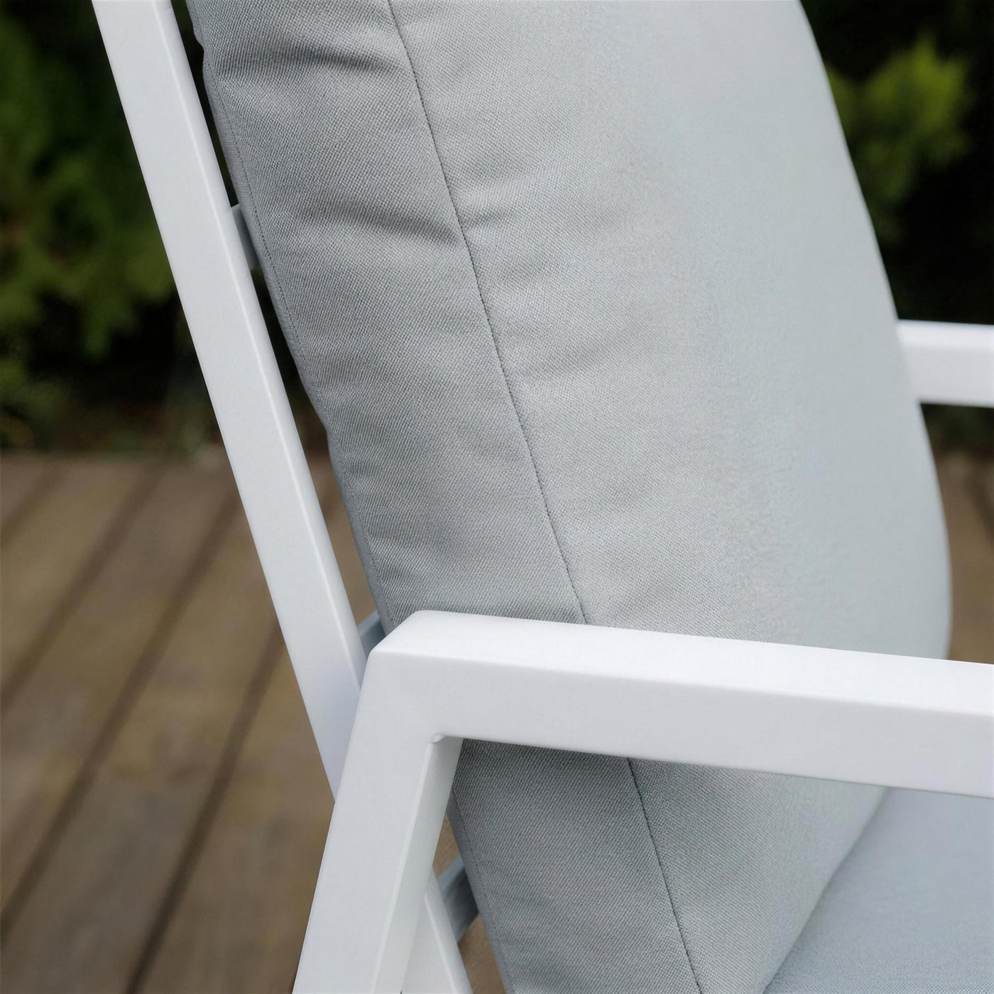 Detalle del respaldo alto del sillon Haston: el perfil de aluminio blanco lacado y la trama del cojin gris claro
