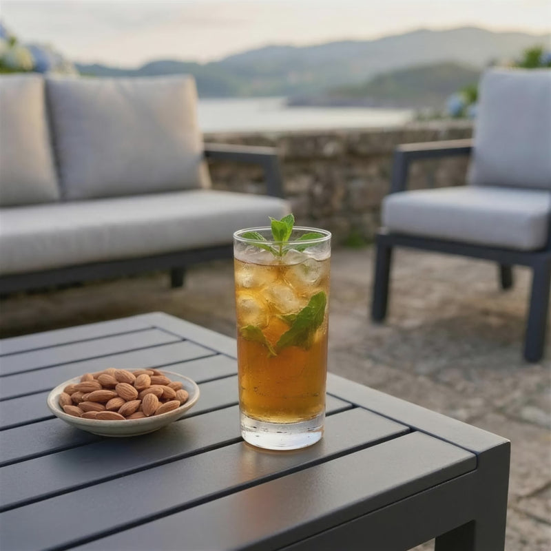 Set de jardín Leisa en terraza junto al mar: bebida fría sobre la mesa de aluminio al atardecer