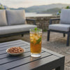 Set de jardín Leisa en terraza junto al mar: bebida fría sobre la mesa de aluminio al atardecer